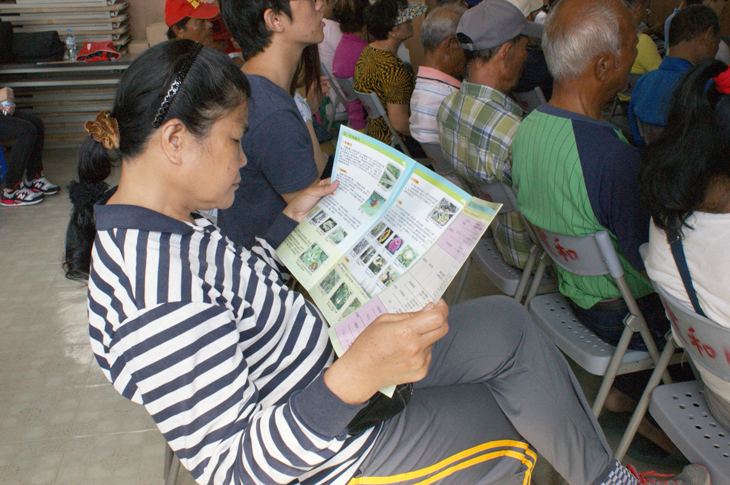 A grower reads an informative pamphlet given out at the seminar.