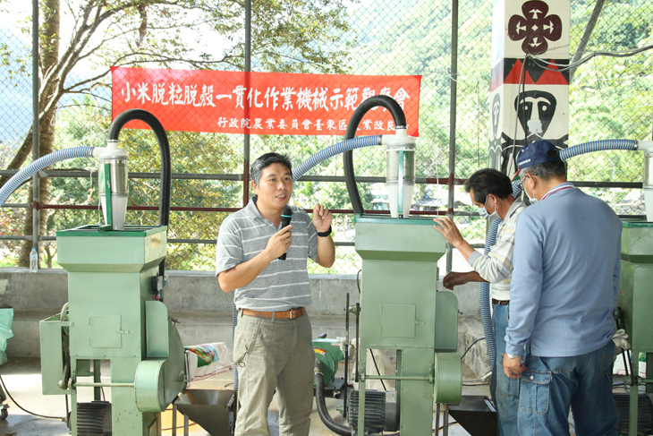 An assistant researcher explains the All-in-One Millet Thresher-Huller.