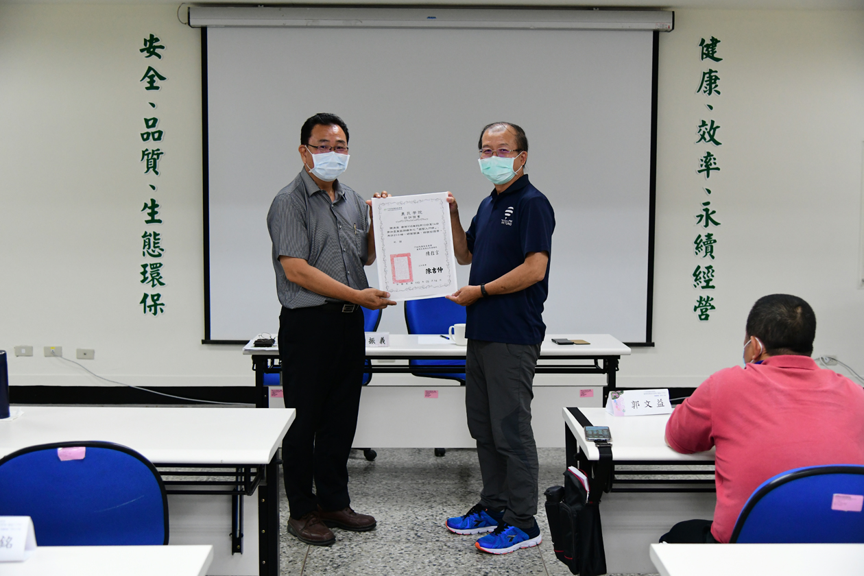Director Chen Hsin-yen presents a certificate of course completion to a participant.
