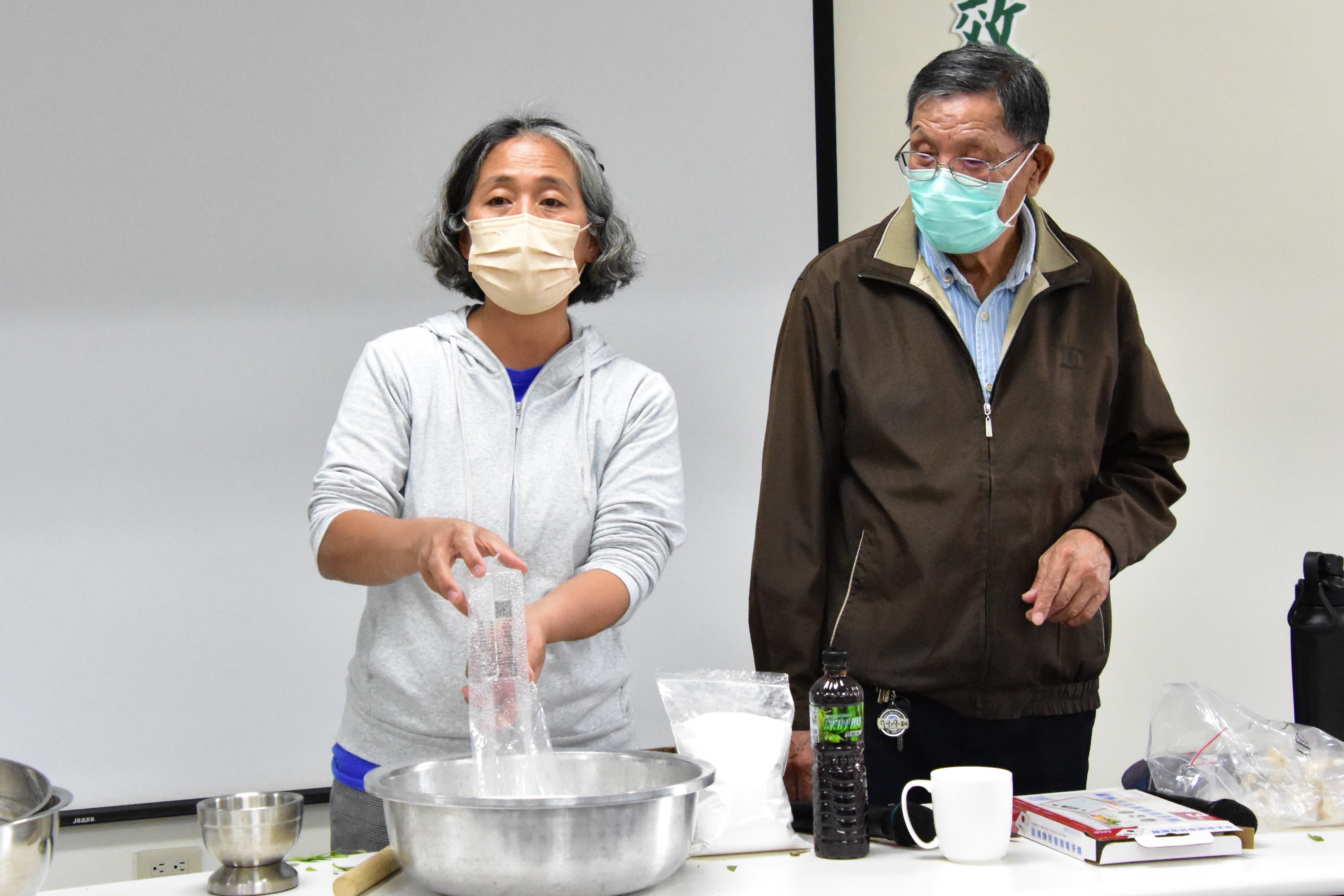 Figure 1. Kaadaadaan Chief Zhang Wan-sheng and community development association executive secretary Pan Bao-ying demonstrate how jiuqu is made.