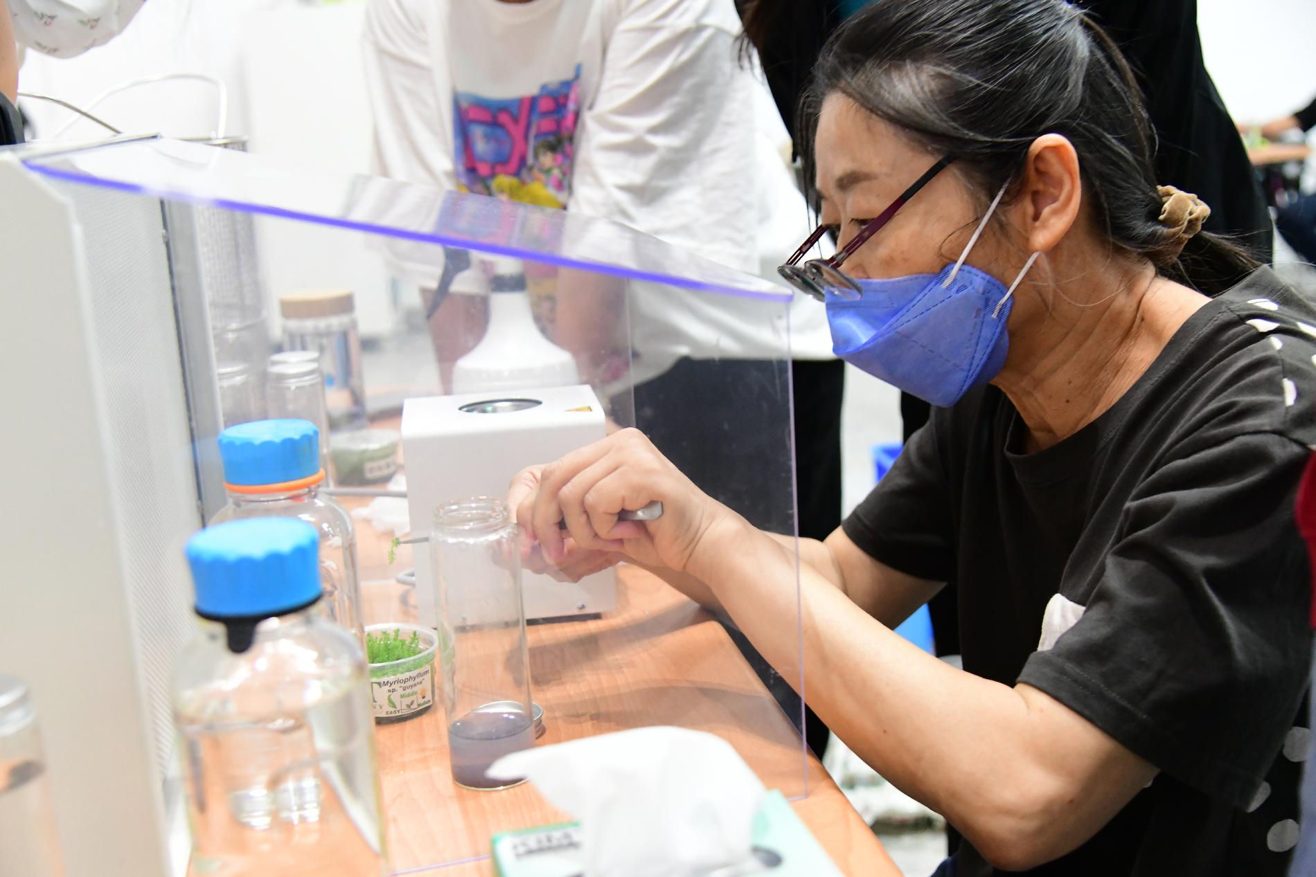 A participant makes an aseptic plant culture bottle.