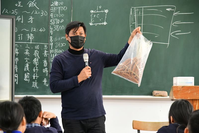 Farmer Lin Chien-chung teaches students about millet.